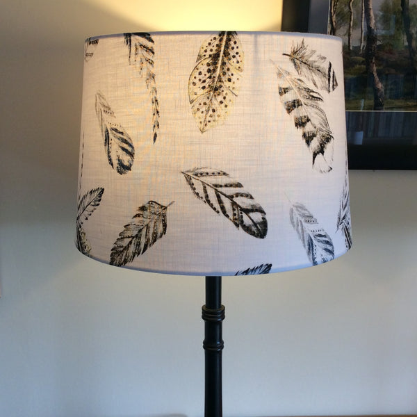 Large tapered hand crafted lamp shade lit.