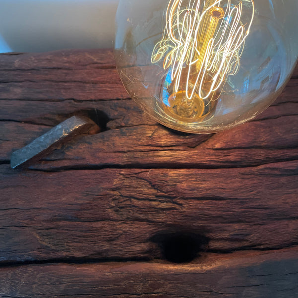 Large wood table lamp crafted by shades at grays from wharf timber, close up of original nail and bolt hole.