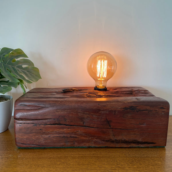 Large wood table lamp crafted by shades at grays from wharf timber with original nail and replica edison bulb, front view