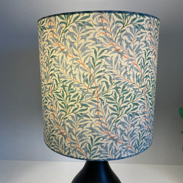 Medium cylinder lampshade in william morris willow boughs cream fabric, lit by shades at grays.