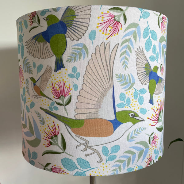 Medium cylinder lampshade with Tauhou Silvereye Birds fabric, handcrafted by shades at grays, unlit.