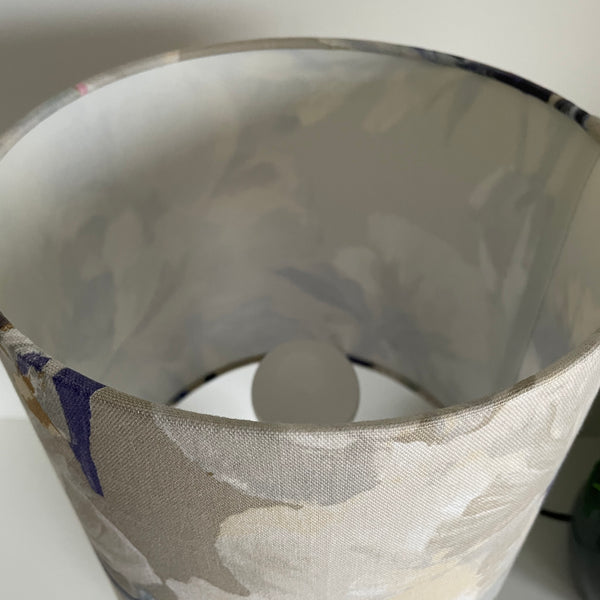 Medium cylinder lampshade with two tone roses blue fabric, showing inner plastic lining, unlit.