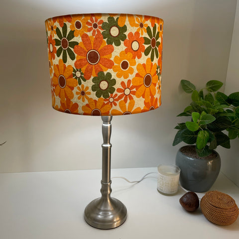 Medium drum handcrafted lampshade nz with mid century flower power fabric on brushed chrome stand, lit by shades at grays.