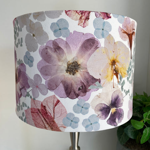 Medium drum lampshade handcrafted by shades at grays with pressed flowers fabric, unlit, close up.