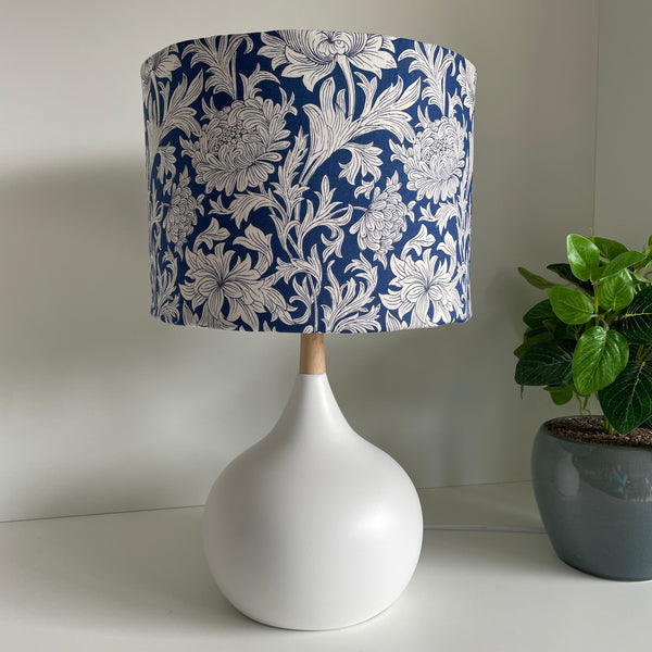 Medium drum lampshade with Morris Chrysanthemum Tonal Blue fabric on white lamp base, unlit, on white base by shades at grays nz. 