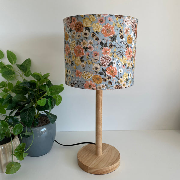 Medium drumshade floral mix fabric, unlit, on a medium wood stand, sold by shades at grays. 