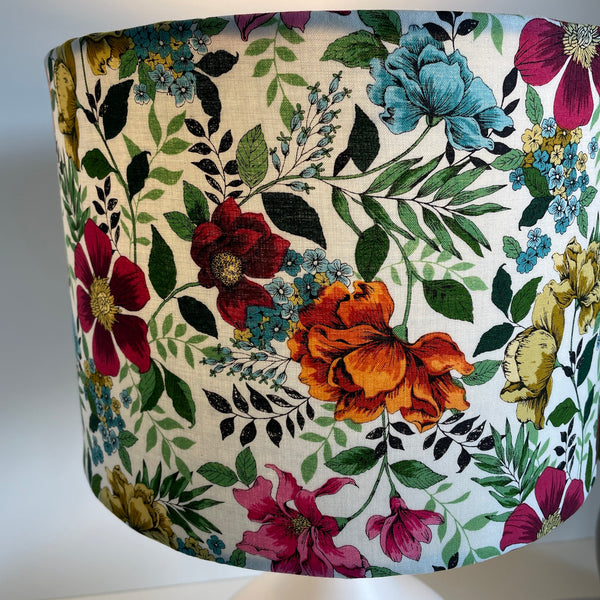 Medium drum bespoke lampshade with flower garden fabric, close up of multi colour flowers and foliage.