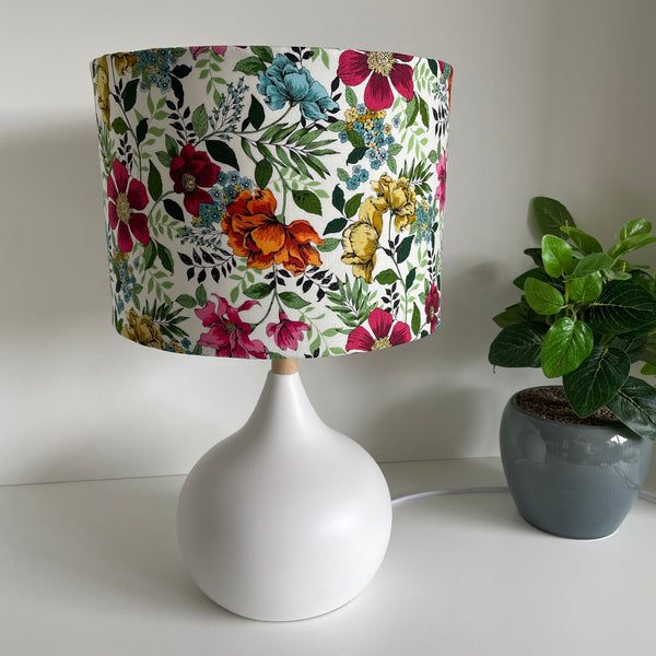 Medium drum bespoke lampshade with flower garden fabric, unlit on white base, by shades at grays nz