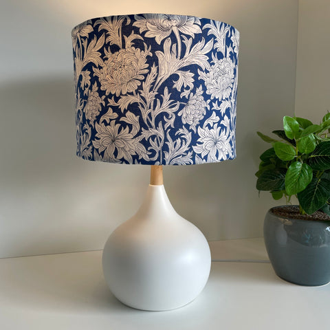 Medium drum lampshade with Morris Chrysanthemum Tonal Blue fabric on white base, lit, shades at grays nz.