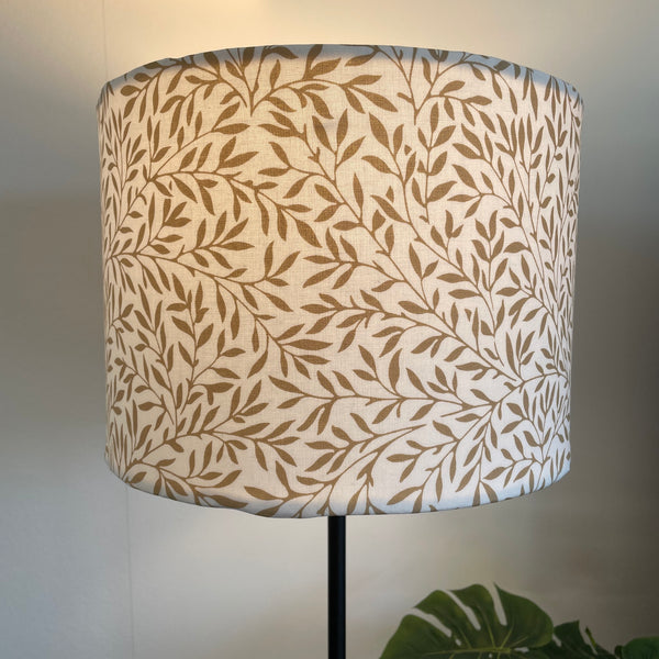 Medium drum style light shade with William Morris Lily Vellum Wandle fabric with brown leaves on cream background, lit by shades at grays nz.