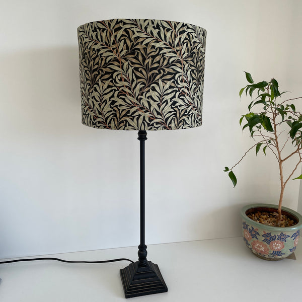 Medium size drum style lampshade with William Morris Willow Boughs black fabric, on black lamp base, unlit, by shades at grays, nz.