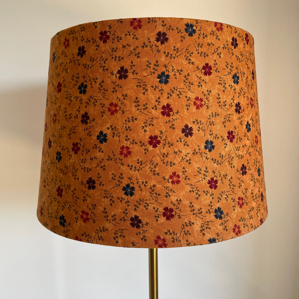 Medium tapered lampshade with cornflowers on brown background, handcrafted by shades at grays, unlit.