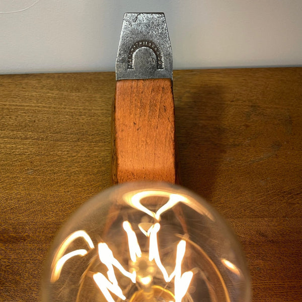 Wood table lamp crafted from authentic carpenters plane, with replica teardrop bulb, lit, close up of bulb, and cutting blade with original branding visible, sold by shades at grays