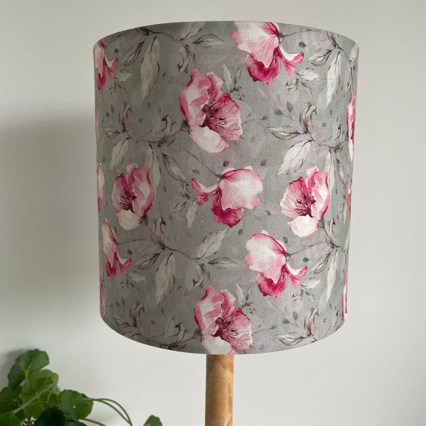 Pink rosebuds on a dove grey background, 20 cm cylinder lampshade, handcrafted by shades at grays, unlit.