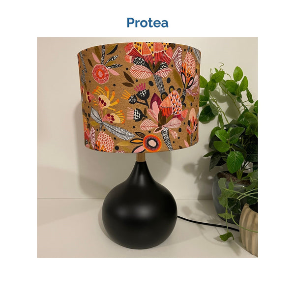 Protea fabric on medium drum lampshade and black touch base, unlit, crafted by shades at grays