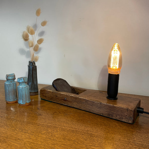 Rare table lamp upcycled from Japanese carpenter's plane with E14 candle bulb, lit.