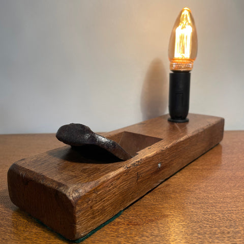 Rare table lamp upcycled from Japanese carpenter's plane with E14 candle bulb, lit by shades at grays.