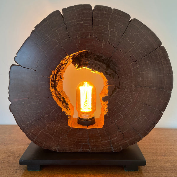 Reclaimed heritage lamp handcrafted by shades at grays from eroded jarrah telegraph pole, lit, front view.