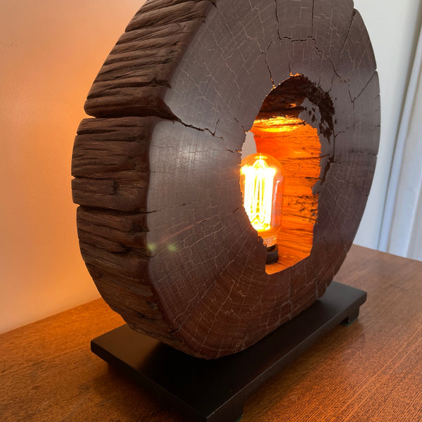 Reclaimed heritage lamp handcrafted from eroded jarrah telegraph pole, lit, left hand side view.