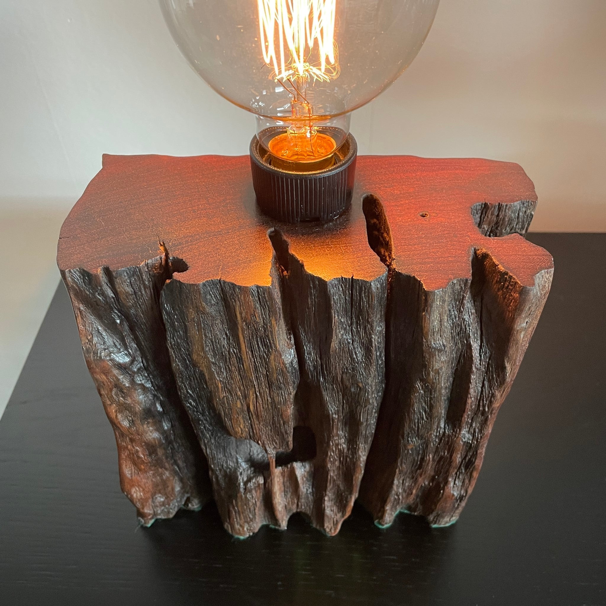 Wood table lamp from reclaimed railway sleeper, with natural erosion and replica edison lamp crafted by shades at grays., top and front view close up.