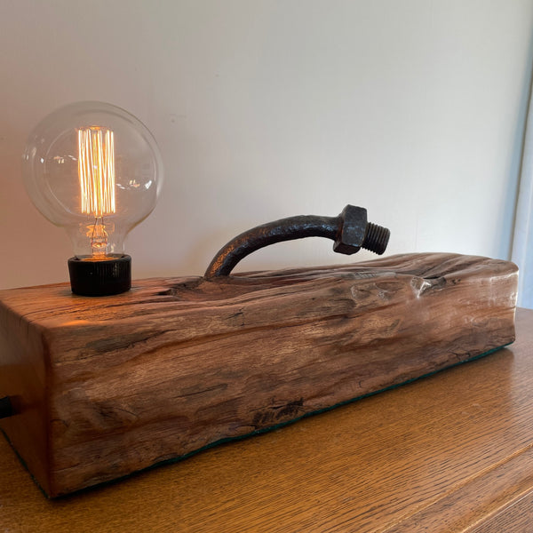 Wood lamp from 100 year old reclaimed wharf timber, with large original bolt, side view, lit, crafted by shades at grays