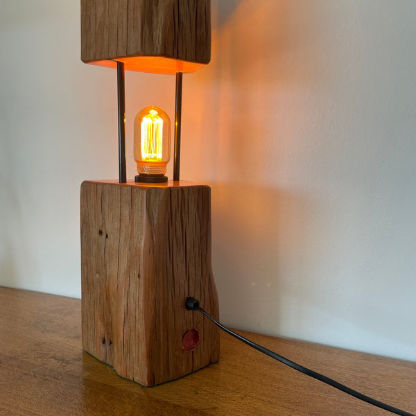 Reclaimed wood table lamp crafted by shades at grays with a split totara post and LED bulb,back view.