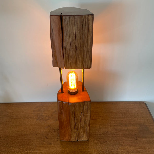 Reclaimed wood table lamp crafted by shades at grays with a split totara post and LED bulb, top and front view.