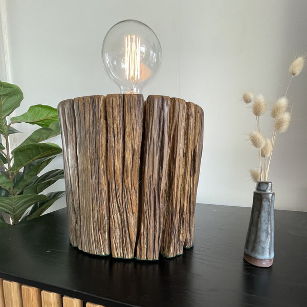 Round telegraph jarrah post upcycled into wood table lamp with addition of edison bulb, lit, long view, crafted by shades at grays.