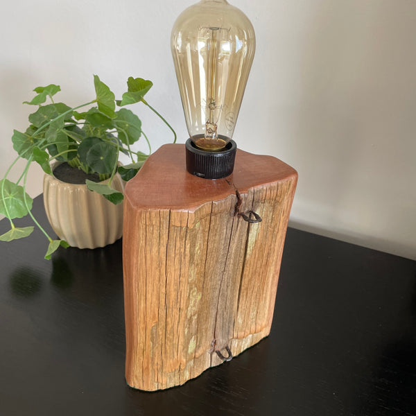 Original totara wood fence post table lamp, crafted by shades at grays, unlit.