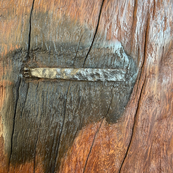 Deep red wood of table lamp handcrafted from 100 year old wharf timber by shades at grays, close up of tar mark and original nail.