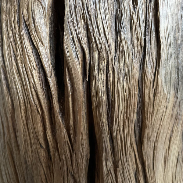 Round wooden table lamp, natural erosion lines, close up.