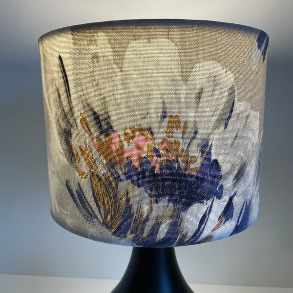 Small drum lampshade with two tone roses blue fabric, lit, large white bloom.