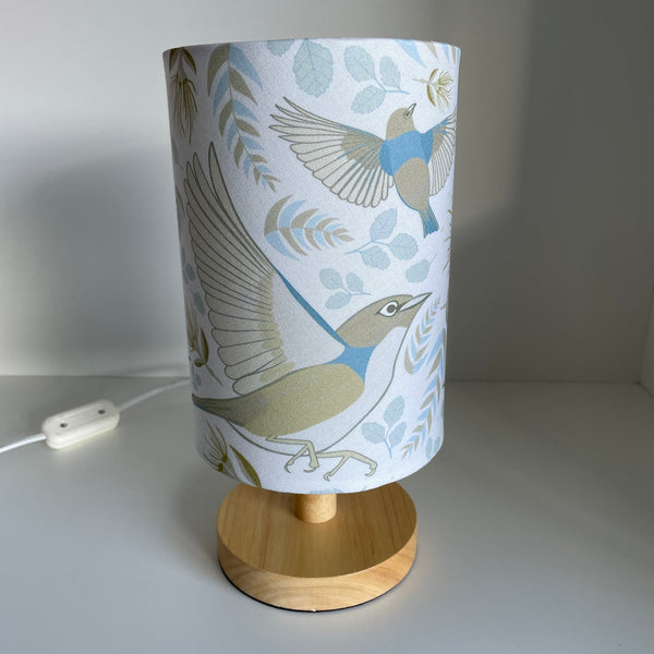 Small table lamp with handcrafted lampshade with Jade Ell's Tauhou Bird Pattern Pale fabric, unlit.