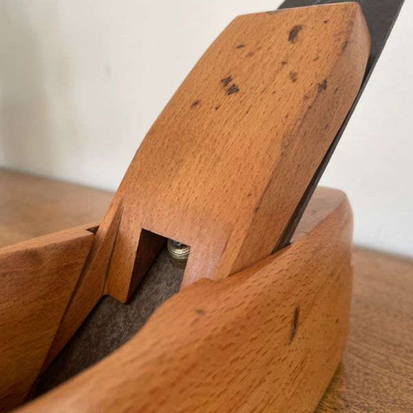 Small carpenters plane upcycled by shades at grays with added replica edison light bulb, close up.