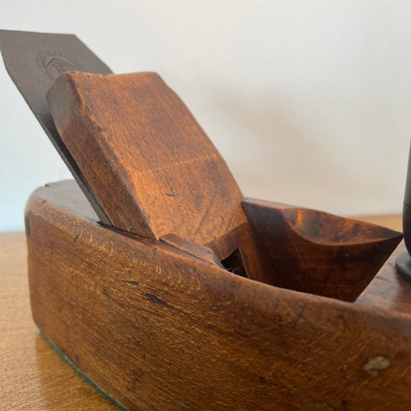 Small table lamp crafted by shades at grays from a vintage carpenter's plane, close up of cutting block and polished surfaces.
