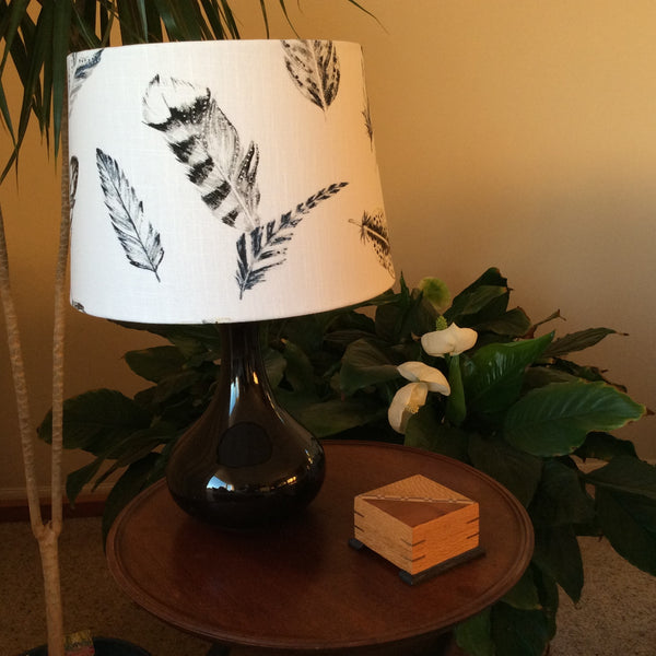 Medium tapered fabric lamp shade hand crafted on black base, unlit.