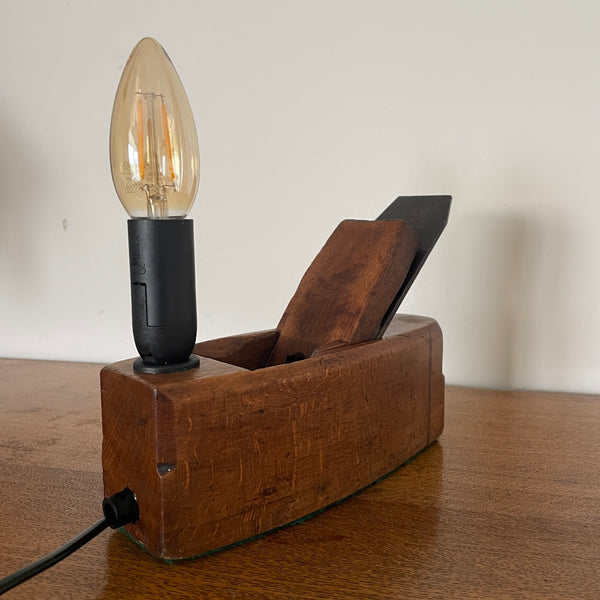 Wooden lamp with a light bulb on a wooden surface