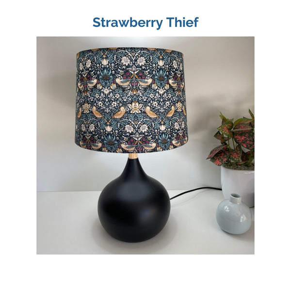 Strawberry thief fabric on medium drum lampshade and black touch base, lit, crafted by shades at grays