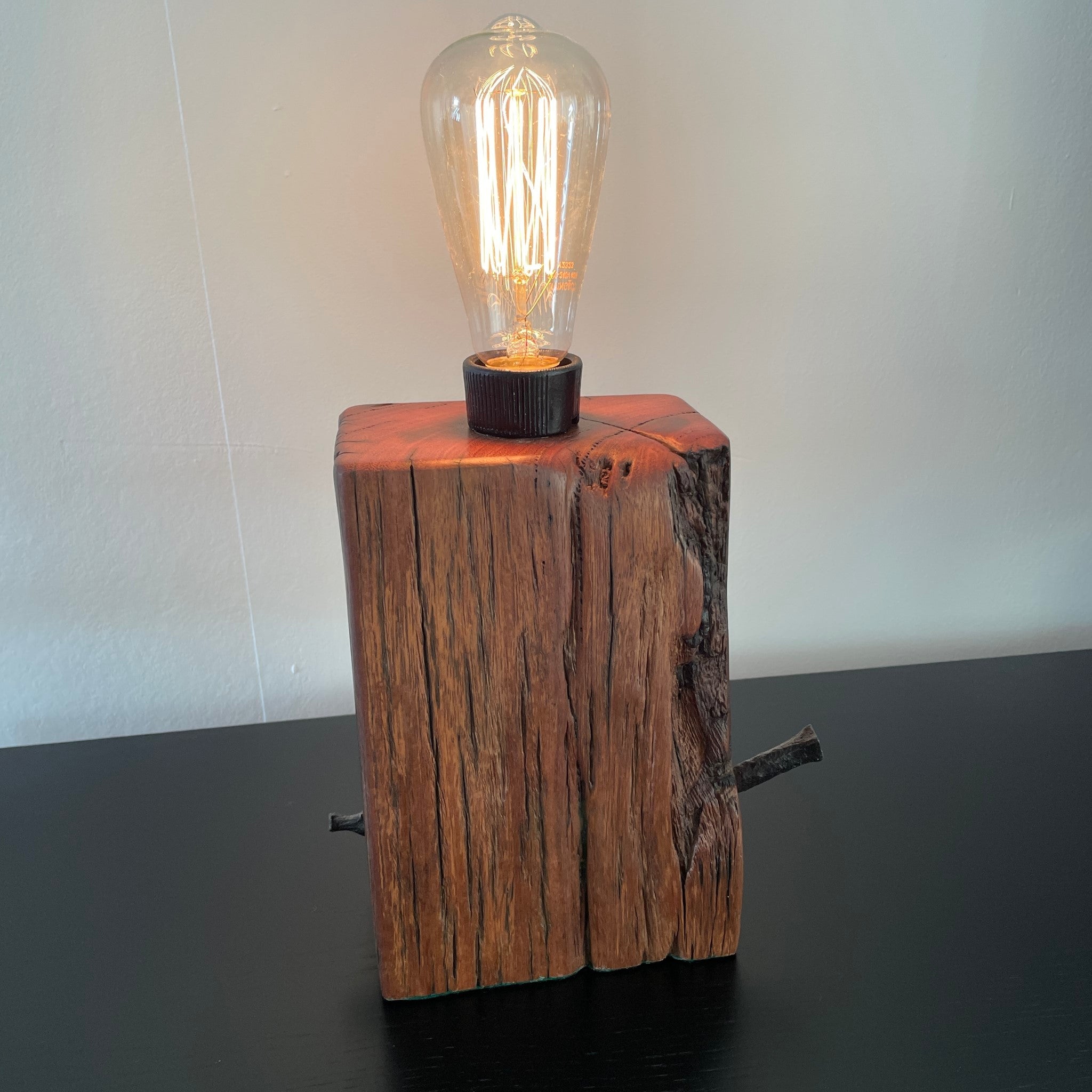 Table lamp, crafted from reclaimed wharf timber, reddish colour wood with deep marks of erosion, made by shades at grays, nz