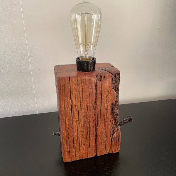 Table lamp, crafted from reclaimed wharf timber, reddish colour wood with deep marks of erosion, unlit, made by shades at grays, nz