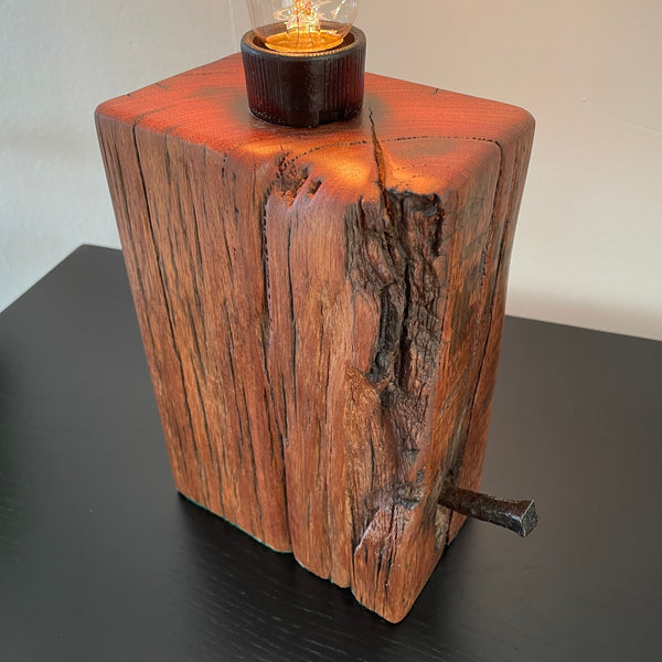 Table lamp, crafted from reclaimed wharf timber, reddish colour wood with eroded corner, made by shades at grays, nz