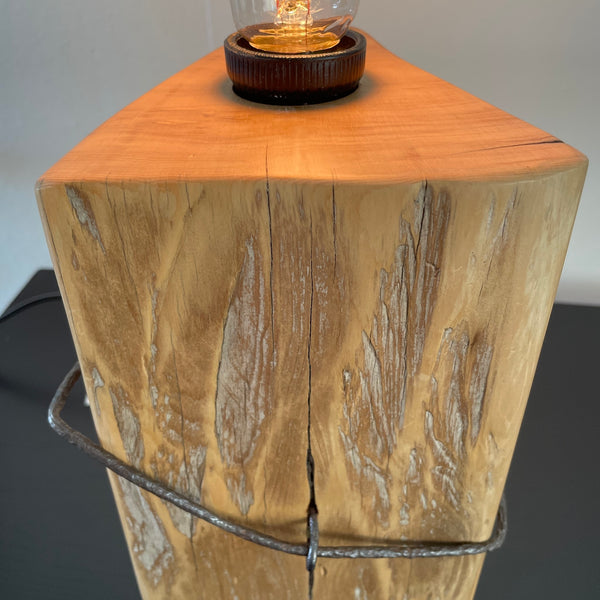 Table lamp crafted by shades at grays, nz, from old tōtara fence post with original iron, close up of original markings.