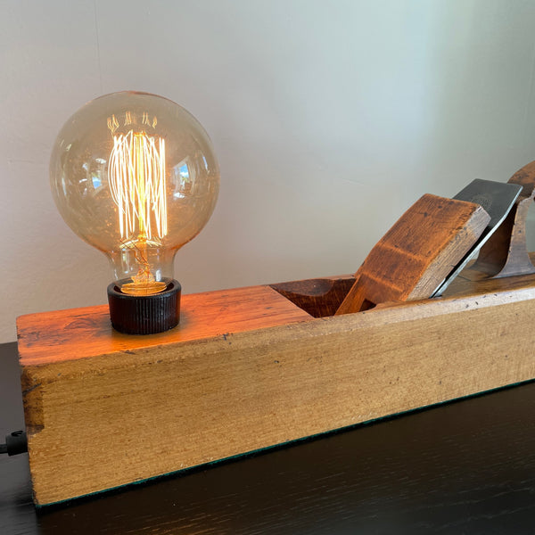 Table lamp made from authentic wood plane by shades at grays, nz, close up of edison bulb.