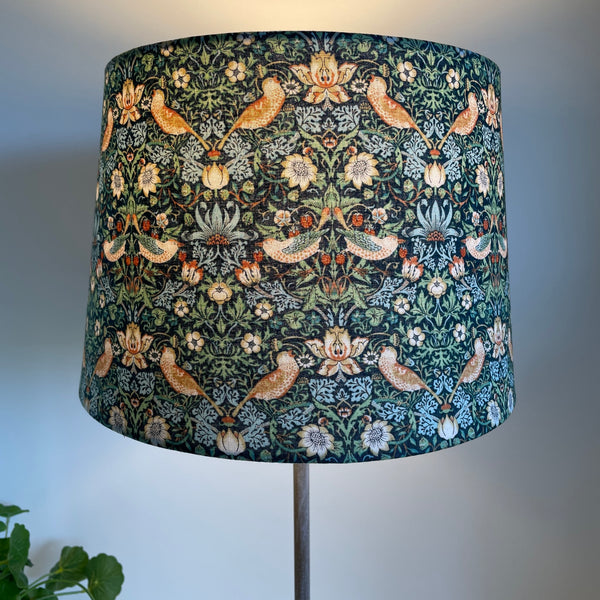 Tapered 24 lampshade with strawberry thief mini marine fabric, lit, crafted by shades at grays.