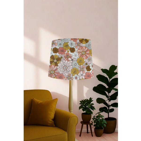 Tapered lampshade handcrafted by shades at grays with boho floral garden fabric on short floor stand in living room.