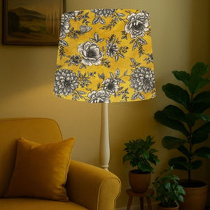 Tapered lampshade handcrafted by shades at grays with floral glow fabric in living room setting.