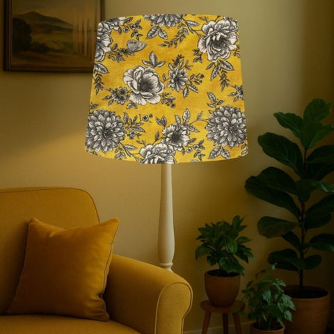 Tapered lampshade handcrafted by shades at grays with floral glow fabric in living room setting.