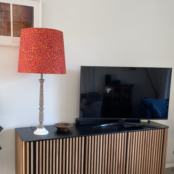 Large tapered lampshade with button mosaic orange fabric, on living room cabinet, handcrafted by shades at grays.