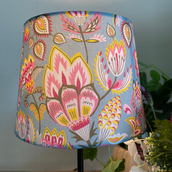 Tapered hand crafted fabric lamp shade, lit.
