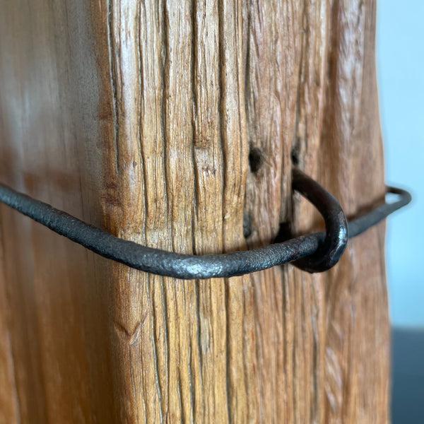 Close up of original wire and staple with polished wood grain.